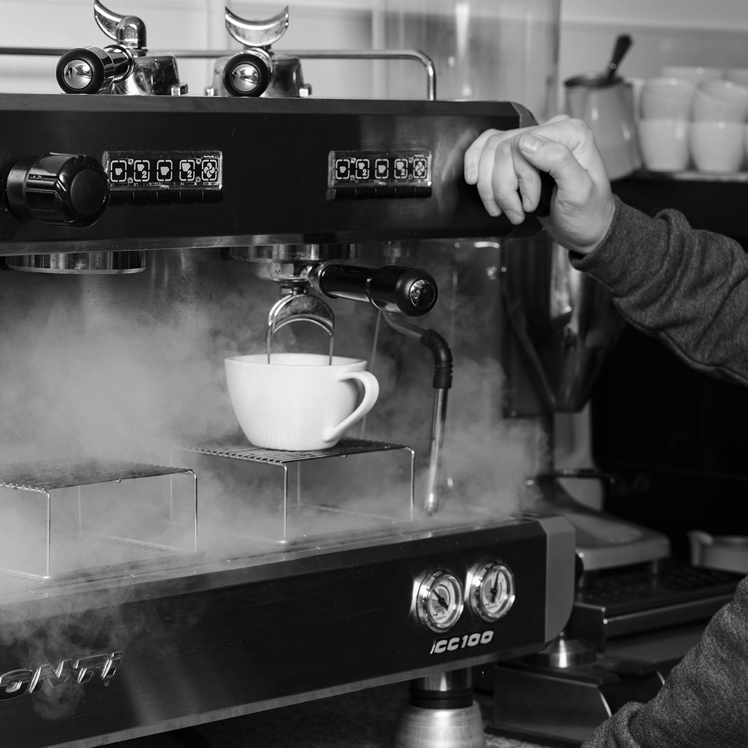 black and white image of a coffee being made on the coffee machine